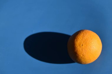 Mavi arka planda olgun bir turuncu ve gölgesi var.