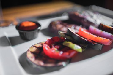 Kızarmış patates, domates ve soğanlı bir tabak et.