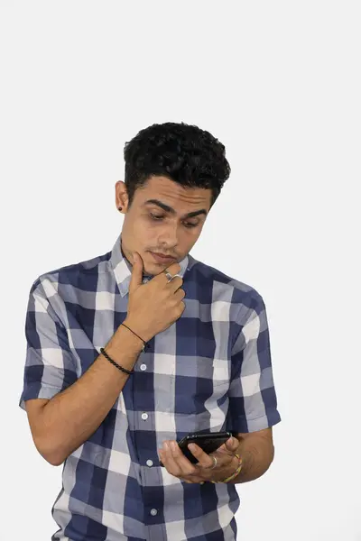 Joven Hombre Mirando Teléfono Pensando Fondo Blanco — Foto de Stock