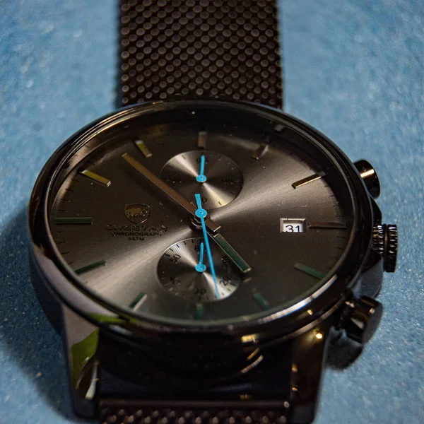 Primer Plano Reloj Pulsera Negro Sobre Una Superficie Azul — Foto de Stock