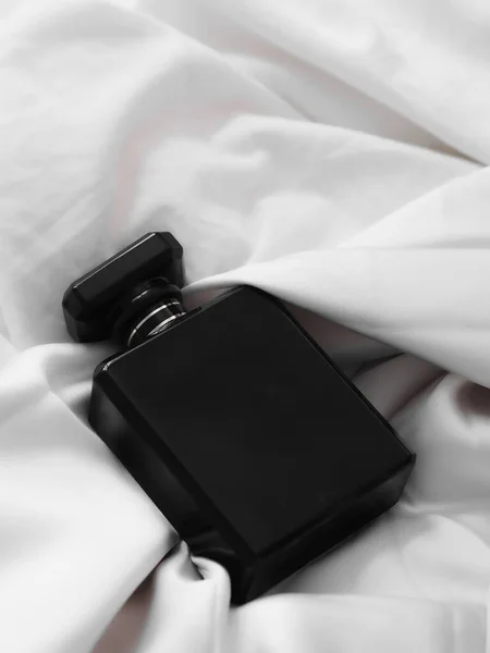Eine Vertikale Aufnahme Einer Luxuriösen Schwarzen Parfümflasche Liegt Auf Einem — Stockfoto