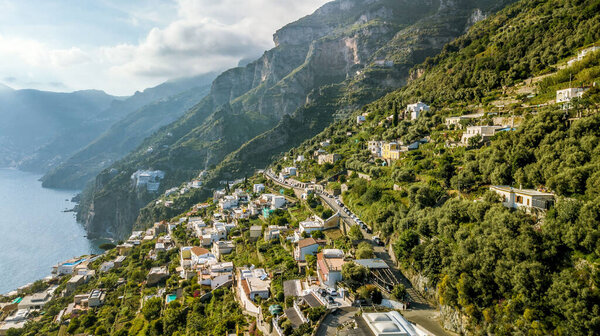Вид с воздуха на синее море на скалистое побережье Амальфи, покрытое зеленью и зданиями в Италии