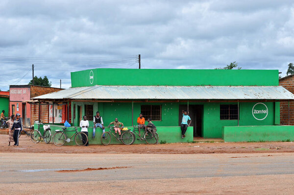 Зелёное здание на перекрёстке с людьми перед ним