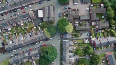Aerial drone lifestyle concept flying over a street lined with British terraced houses during the golden hour as the sun is setting.