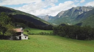 A drone view of a countryside house in beautiful nature with fields and mountains