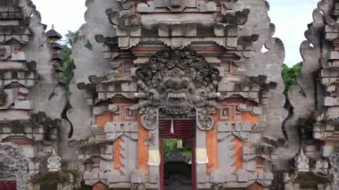 A drone shot of the beautiful Asian design of a temple in Indonesia with trees in the background