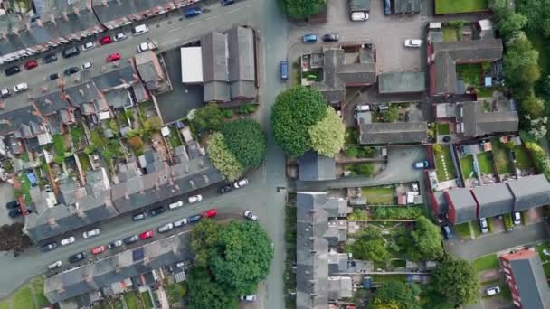 太陽が沈む黄金の時間の間に英国のテラスハウスが並ぶ通りを飛行する空中ドローンライフスタイルの概念 — ストック動画