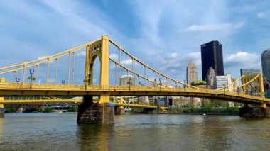 The cloudy blue sky over Andy Warhol Bridge seen from the Allegheny river waterfront with the Pittsburgh downtown in the background