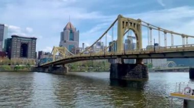 The cloudy blue sky over Andy Warhol Bridge seen from the Allegheny river waterfront with the Pittsburgh downtown in the background