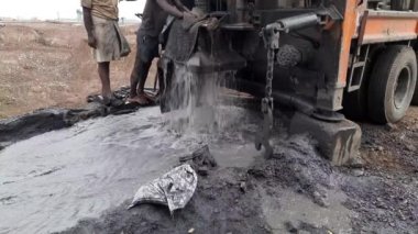 A Labor is changing borewell ring pipe while digging borewell with borewell machine - Borewell Ring Pipe