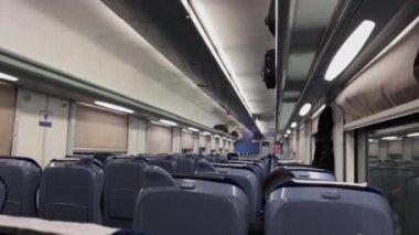A row of train seats inside a second class cabin