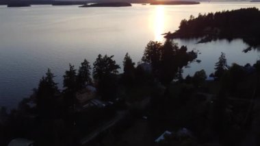An aerial view of a lake with mountains during the sunset