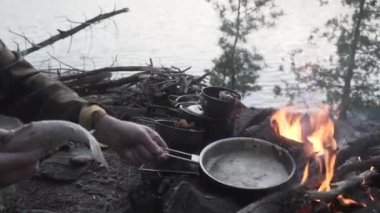 Kuzey Ontario Crownlands 'de kamp yaparken balık pişiren bir kişinin HD' si.