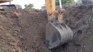 Excavator at work. backhoe mechanical shovel working on the field, dig around or dig for a center pillar,