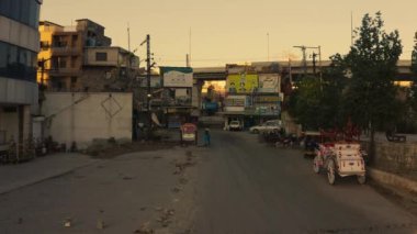 A drone shot of small street with signs, old cars and old shops in Rawalpindi city Pakistan