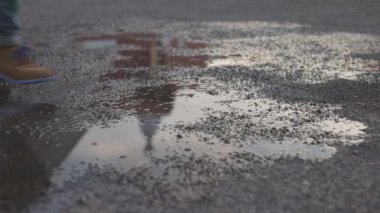 A closeup of a man stepping into the puddle in Cape Town, South Africa
