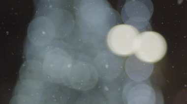 An urban decorated street in the evening during snowfall