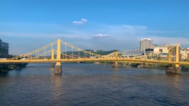 The blue sky over Andy Warhol Bridge seen from the Allegheny river waterfront with the Pittsburgh downtown in the background