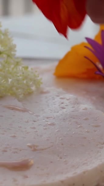 用自然花朵装饰素食蛋糕作为顶部的过程中的紧密垂直镜头 — 图库视频影像
