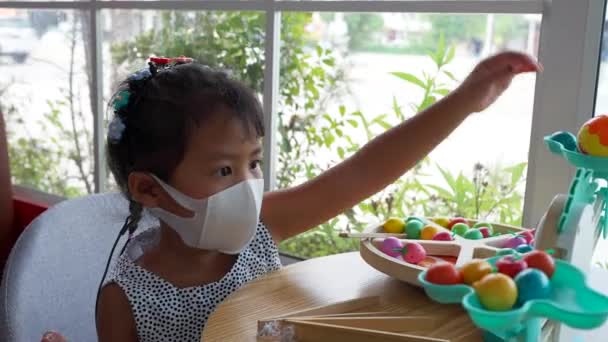 Shallow Focus Adorable Southeast Asian Girl Protective Mask Playing Toy — Video Stock