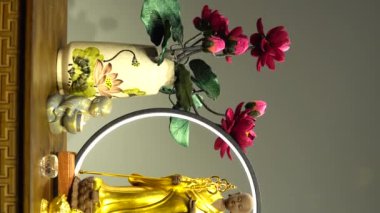 A closeup view of a small statue of Buddha on the table with decorations