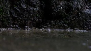 A view of mineral water against a black rock