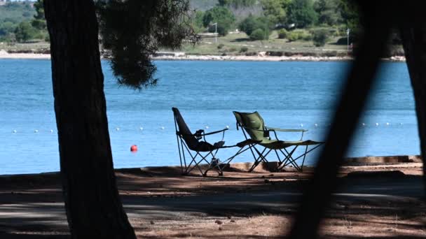 Shore Lake Two Foldable Beach Chairs Tree Shadow — Stockvideo