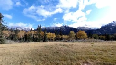 Time-lapse of the color autumn nature, blue sky with white clouds, color trees and mountains in the background