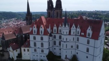 it is shown a nice cathedral where a car meet takes place