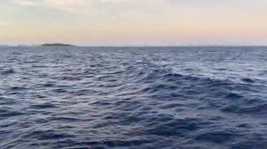 4K Seascape footage of navy blue waves  taken from a white boat