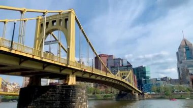 The cloudy blue sky over Andy Warhol Bridge seen from the Allegheny river waterfront with the Pittsburgh downtown in the background