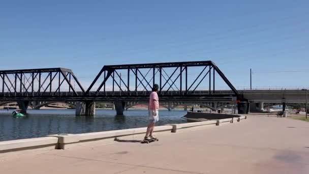 アリゾナの晴れた日にテンペの町の湖の歩道でスケートをしている人たち — ストック動画