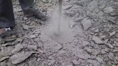 A Destruction of a rock pile with drill machine jackhammer, closeup view.