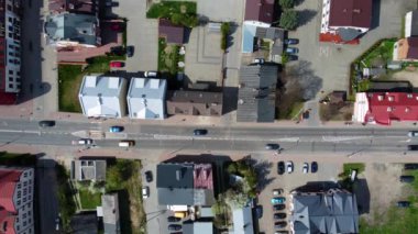 A top view of cars driving along the street with houses around