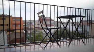 A complete transition from rain to sunlight with moving clouds on the background in a balcony with a chair and table, out of focus background