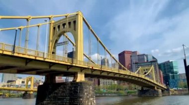 The cloudy blue sky over Andy Warhol Bridge seen from the Allegheny river waterfront with the Pittsburgh downtown in the background