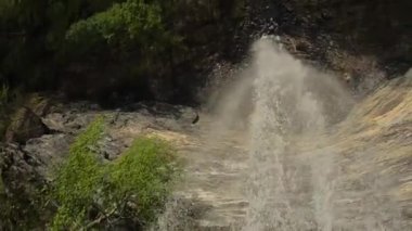 A drone flying between the splash in the waterfall