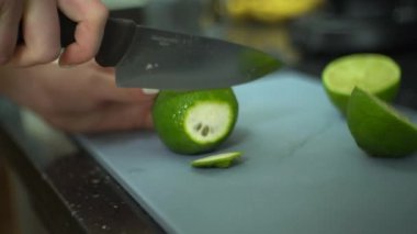 A female cutting lime on board