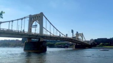 The blue sky over Andy Warhol Bridge seen from the Allegheny river waterfront with the Pittsburgh downtown in the background