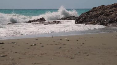 A beautiful view of ocean waves with foam on a sandy beach