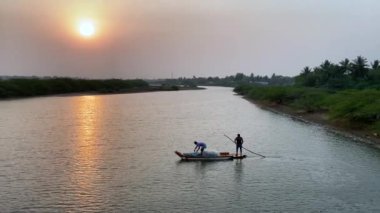 A boat floating on a river on the sunset