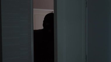 A robber trying to enter a room in the house