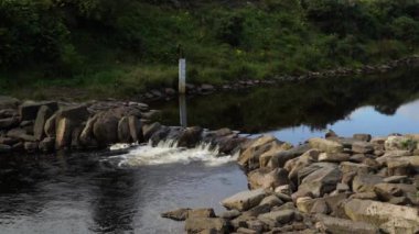 A scenic view of the weir on a flowing river in Dunbeath Strath, Scottish Highlands