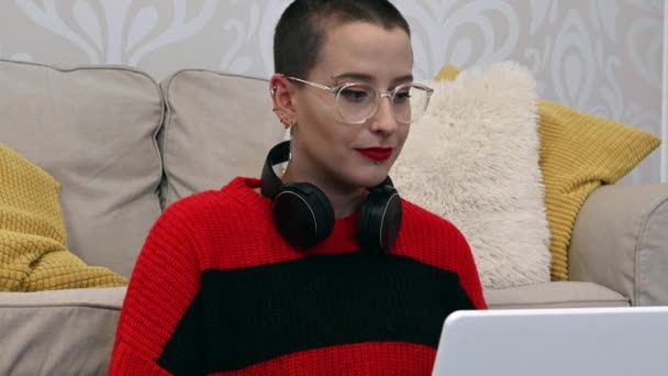 Caucasian Female Short Hair Glasses Earrings Black Headphones Chatting Laptop — Video Stock
