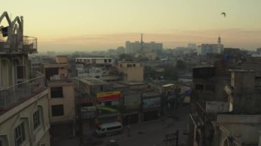 A drone shot of an old buildings and houses with parked cars in a small street in Rawalpindi city, Pakistan