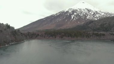 A beautiful view of Quetrupillan volcano in Villarrica National Park surrounded by trees and laguna