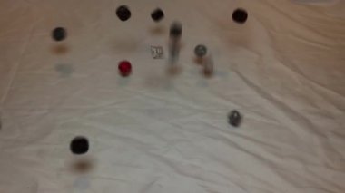 A bunch of different dice falling on a white bedsheet