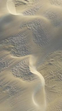 An aerial view of sand dunes by sea at daytime