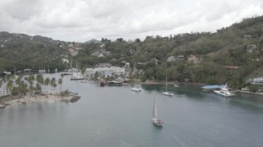 A drone footage above a water area with boats gliding over in St Lucia, an island in the Caribbean
