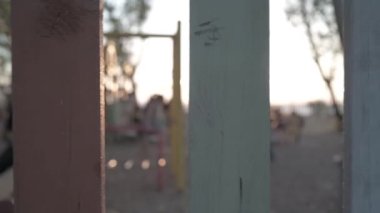A slow motion of kids playing in the yard captured from behind the wooden fence